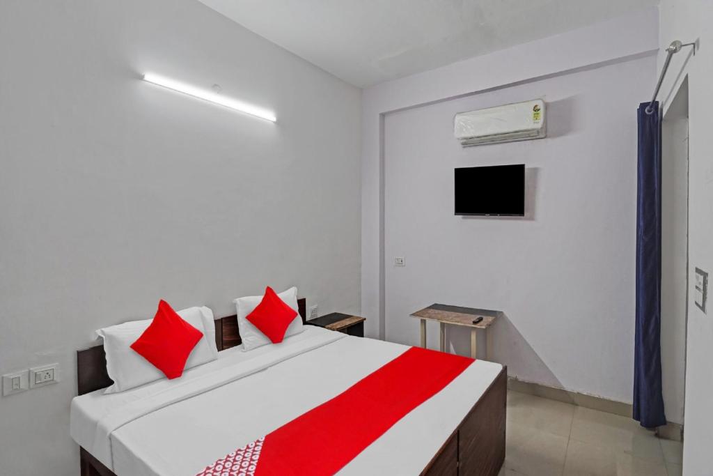 诺伊达OYO Hotel Grand Shiva的一间卧室配有红色枕头的床