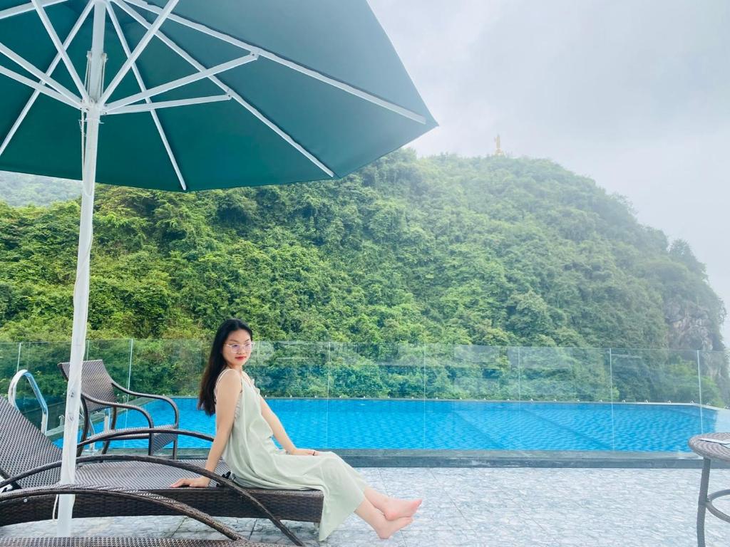 吉婆岛Sand Hotel的坐在一把伞下椅子上的女人
