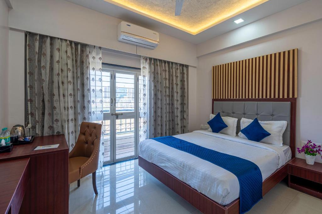 浦那StayBird - Divine Suites, Business Hotel, Kharadi的配有一张床、一张书桌和一扇窗户的酒店客房