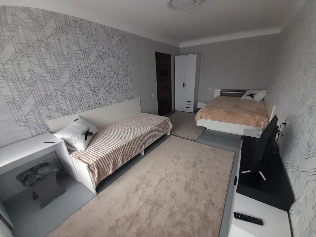 罗夫诺Апартаменти біля Автовокзалу的一间小卧室,配有两张床和一张书桌