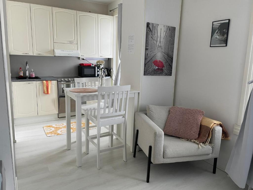 许温凯Yksiö+autopaikka/Small apt.+free parking的厨房配有白色的桌子、椅子、桌子和椅子