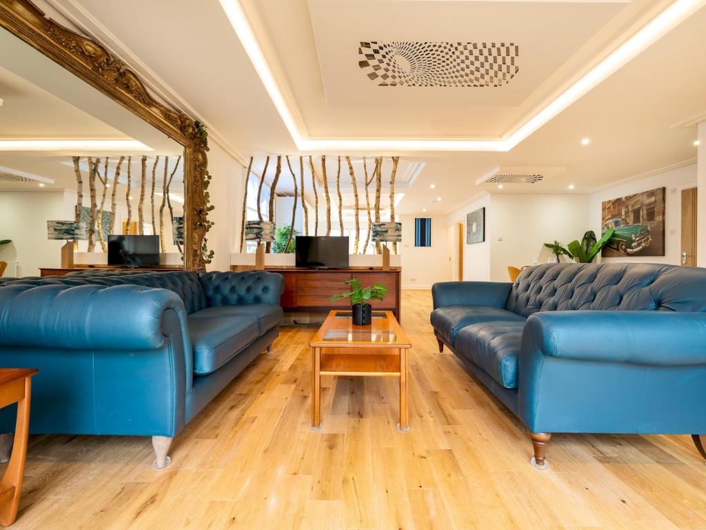 阿默舍姆Lux Light Spacious- Chilterns Pass the Keys的客厅配有蓝色的沙发和桌子