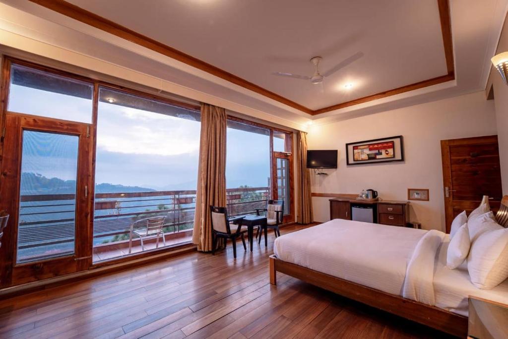 柴尔Nature View Resort !! A Four Star Lavish & Luxury Resort的酒店客房设有一张床和一个大窗户