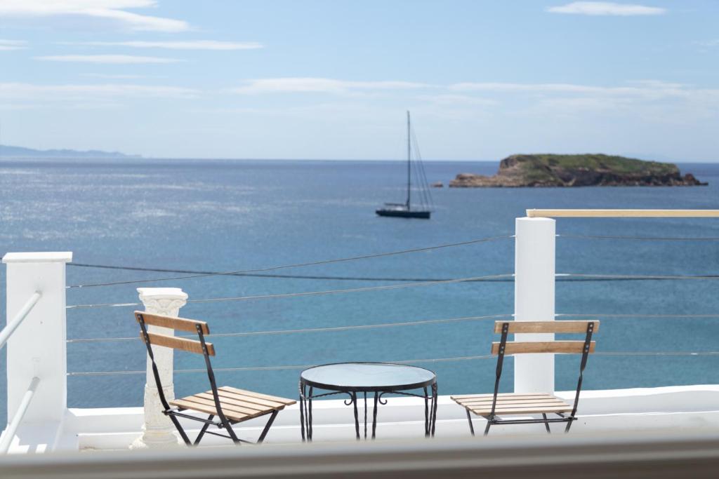 苏尼翁Poseidon Apartments and Villas by the Sea的阳台上配有两把椅子和一张桌子,享有海景