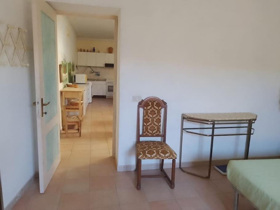 奎尔瑟Casa vacanze Sa Rocchitta的配有桌椅的房间和厨房