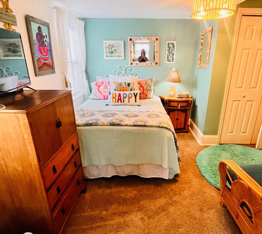 泰比岛Pearls Pad - Beautiful 1 bedroom apartment- 1 block to beach的一间卧室配有一张床,上面有快乐的枕头