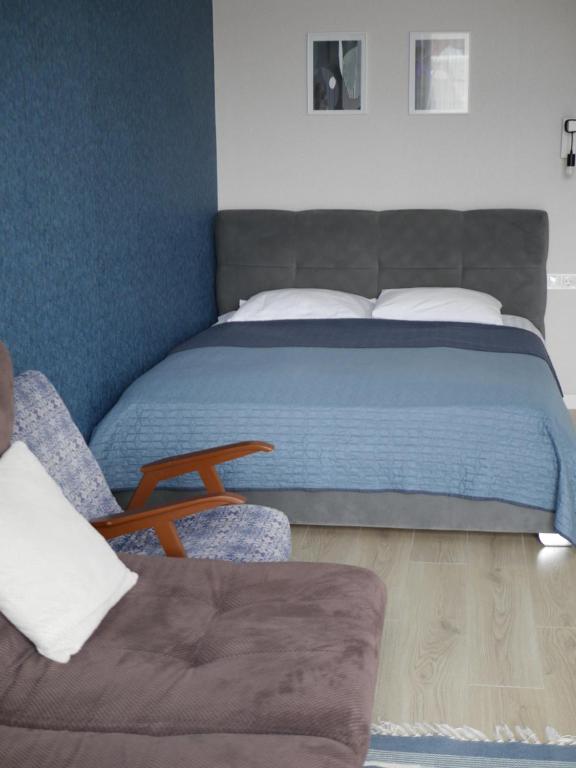 罗夫诺Prestige Apartments的一间卧室配有一张床、一张沙发和一把椅子
