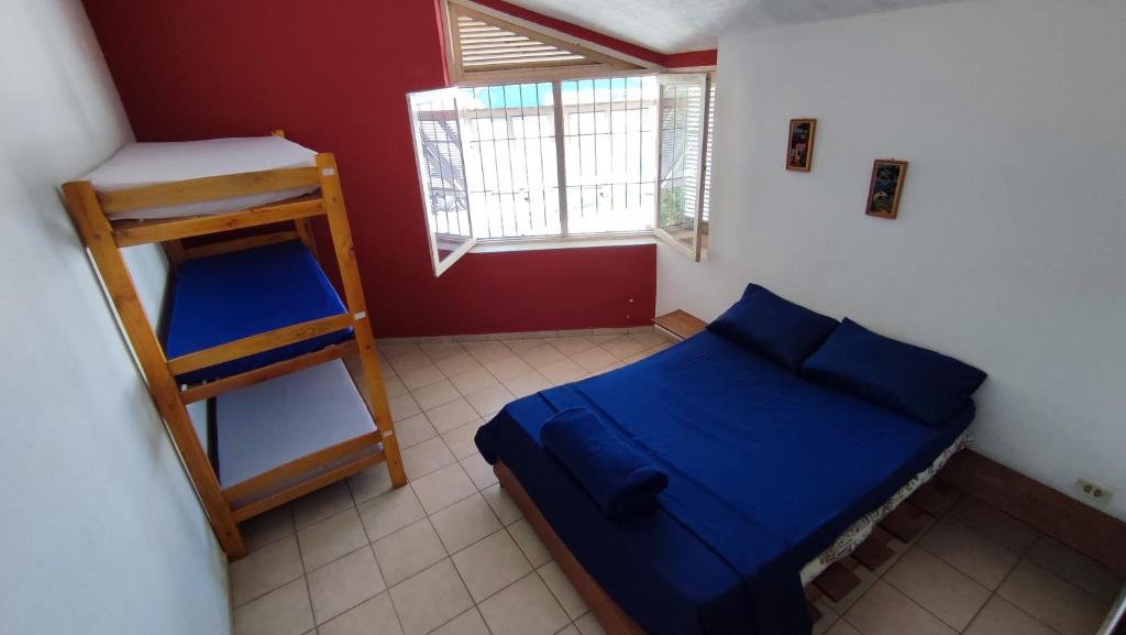 乌巴图巴Maré Alta Hostel的一间小卧室,配有蓝色的床和梯子