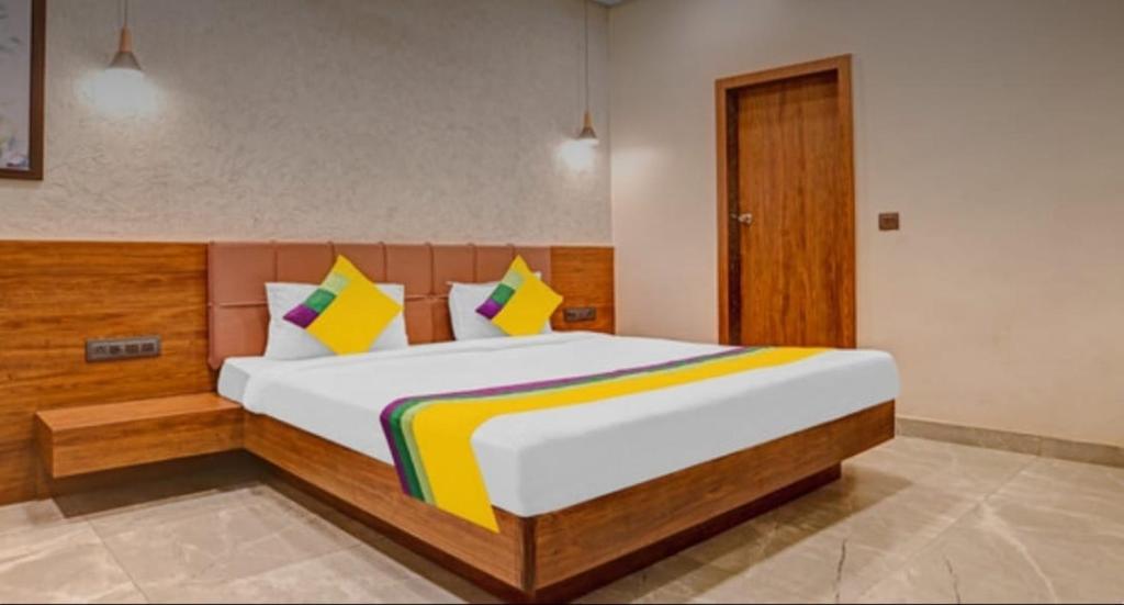 伯杰默里Hotel Abhilasha inn的一间卧室配有一张带色彩缤纷枕头的大床