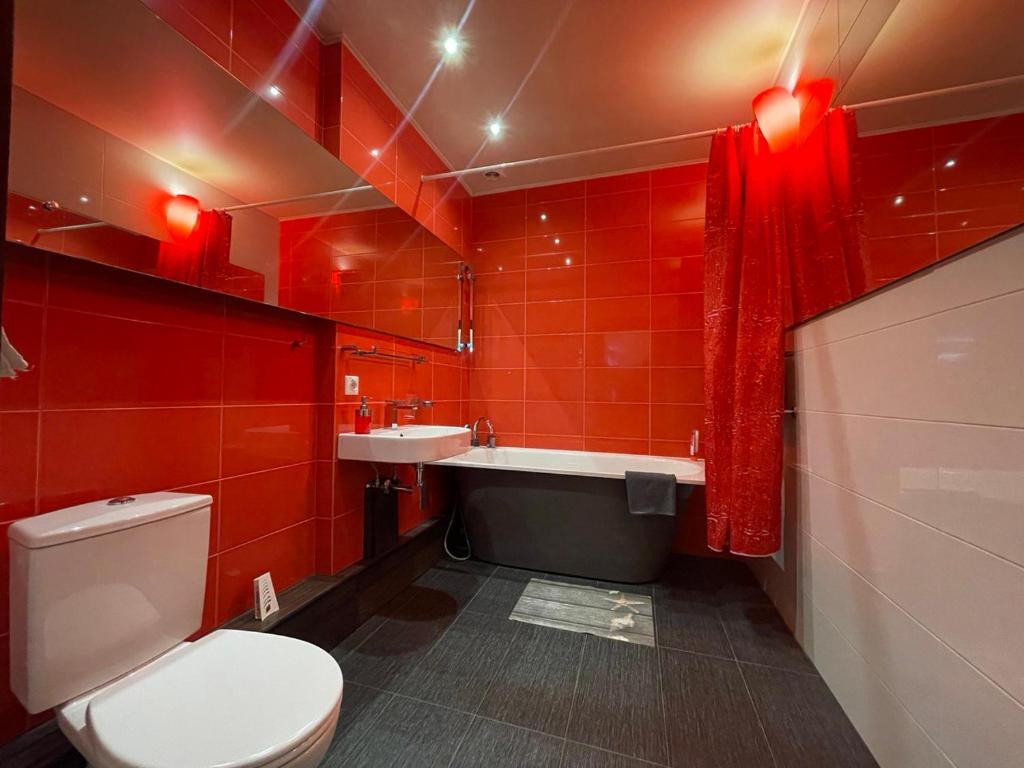 尤尔马拉Meza House Apartment的红色的浴室设有卫生间和水槽
