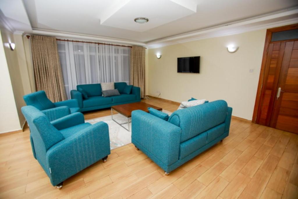 MeruWHITE LOTUS EXECUTIVE APARTMENT的客厅配有2张蓝色沙发和1台电视