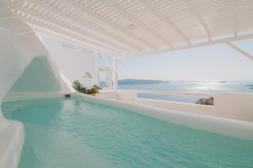 费拉Apeiron Blue Santorini - Sustainable Adults Only 14 Plus的蓝色的白色建筑中的游泳池