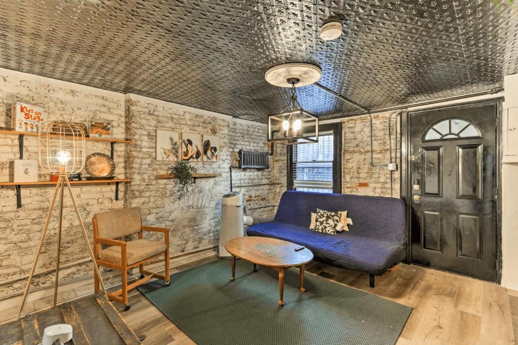 泽西市1850s historic Row House 7min train to NYC with private backyard的客厅配有蓝色的沙发和椅子