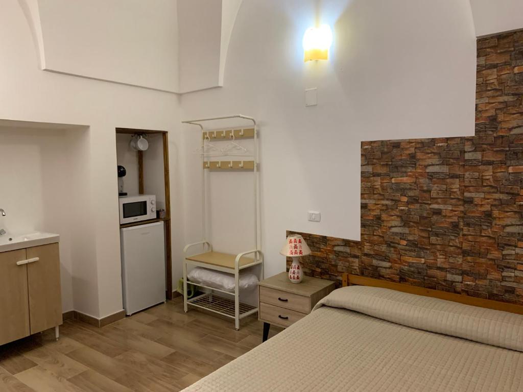 切列梅萨皮卡Le Camere Dei Mascia的一间卧室设有一张床和砖墙