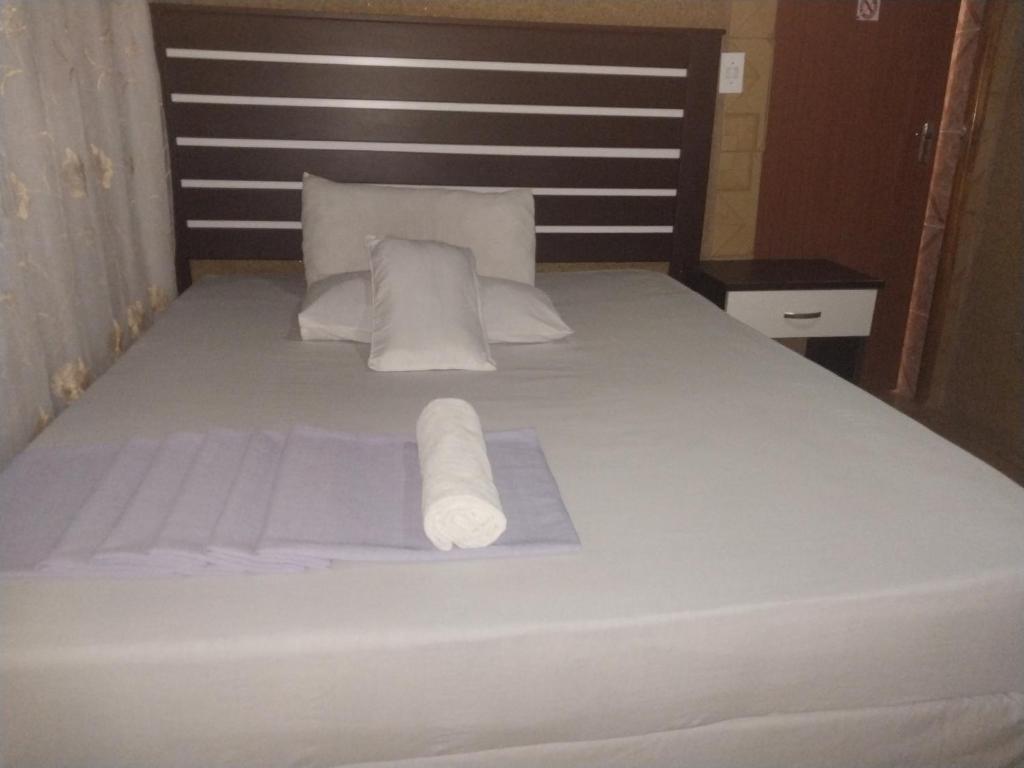 PhuthaditjhabaM-Dee Guest Pass Lodge的一张床上有两卷白色毛巾的床
