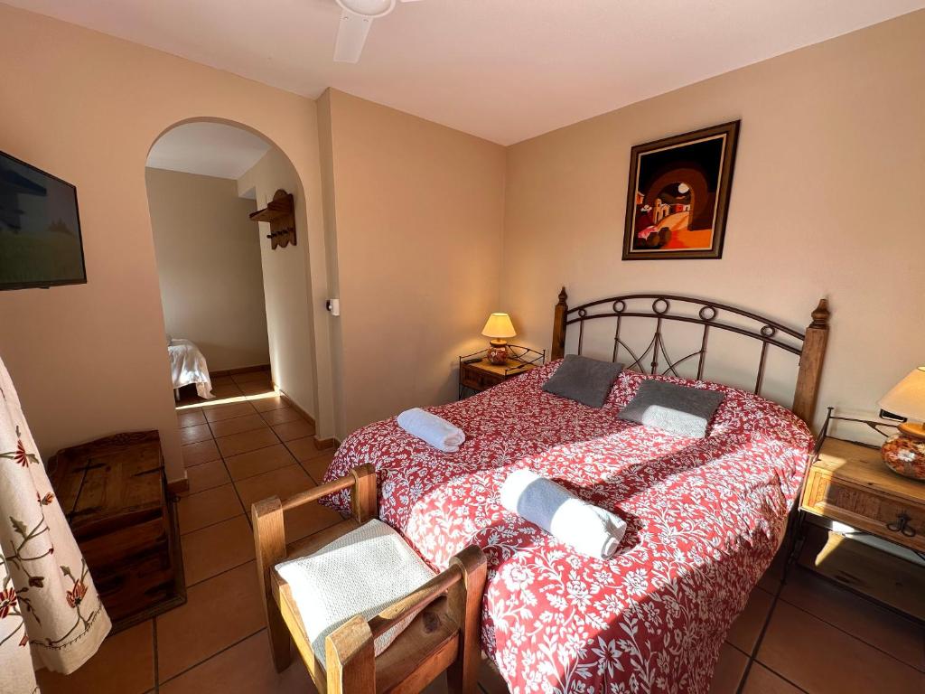 GandullasPosada La Fragua的一间卧室配有一张带红色和白色棉被的床