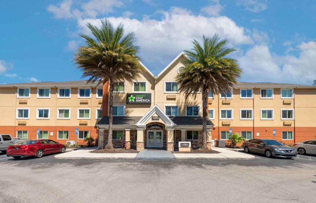 杰克逊维尔Extended Stay America Select Suites - Jacksonville Salisbury Rd Southpoint的前面有两棵棕榈树的酒店