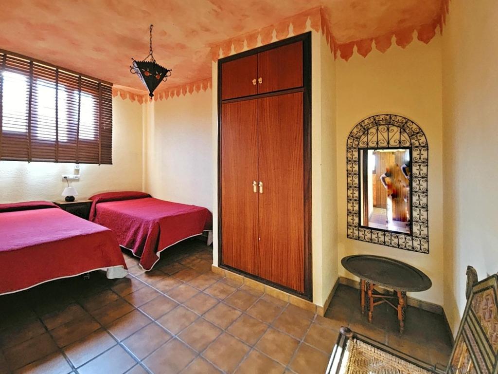 瓜迪亚纳河畔桑卢卡尔Casas Rurales Los Molinos的一间卧室配有两张床、一张桌子和一面镜子