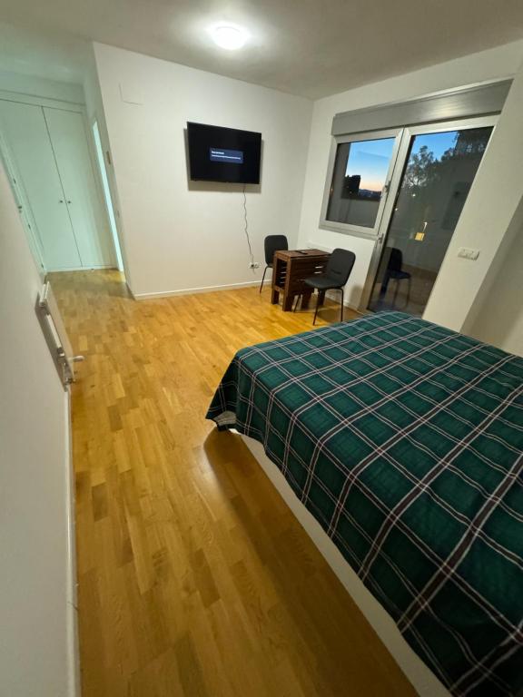 马德里Hotelly Recuero的一间卧室配有一张床、一张桌子和一台电视