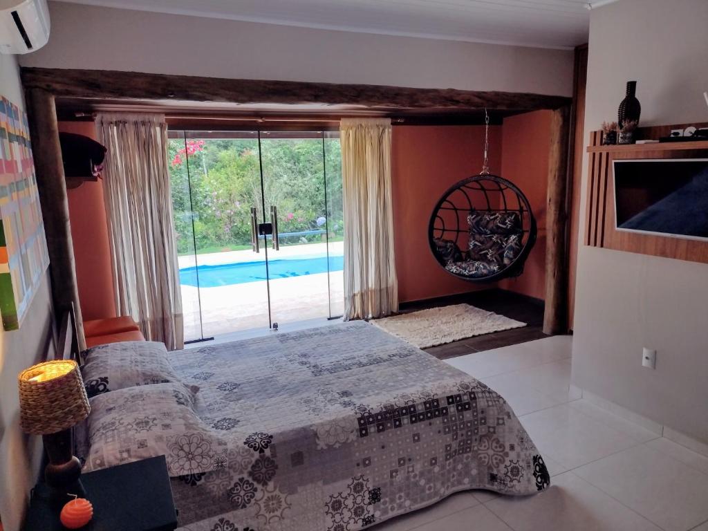 弗洛里亚努元帅镇Sítio Cachoeirinha的一间卧室配有一张床,享有游泳池的景色