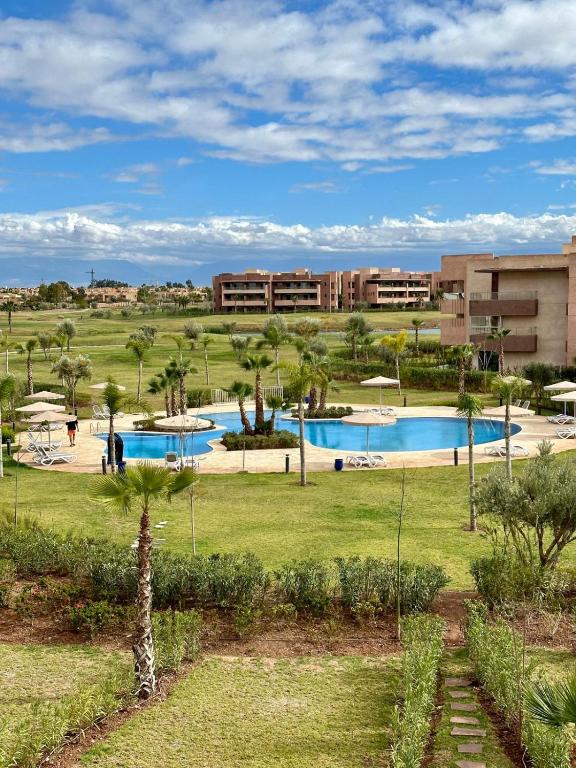 马拉喀什Appartement Prestigia 3 chambres的度假村设有两个游泳池和棕榈树