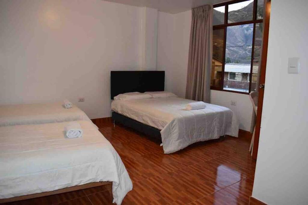 YungayCasa acogedora en Mancos, Yungay的一间卧室设有两张床和窗户。