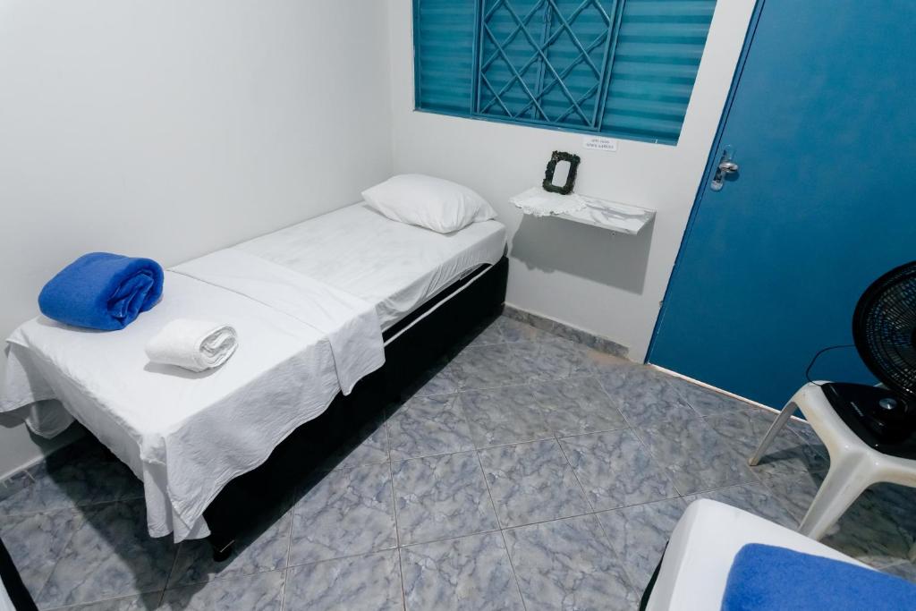 乌贝兰迪亚Quarto 04 Pousada Roosevelt的一间小卧室,配有一张带蓝色门的床