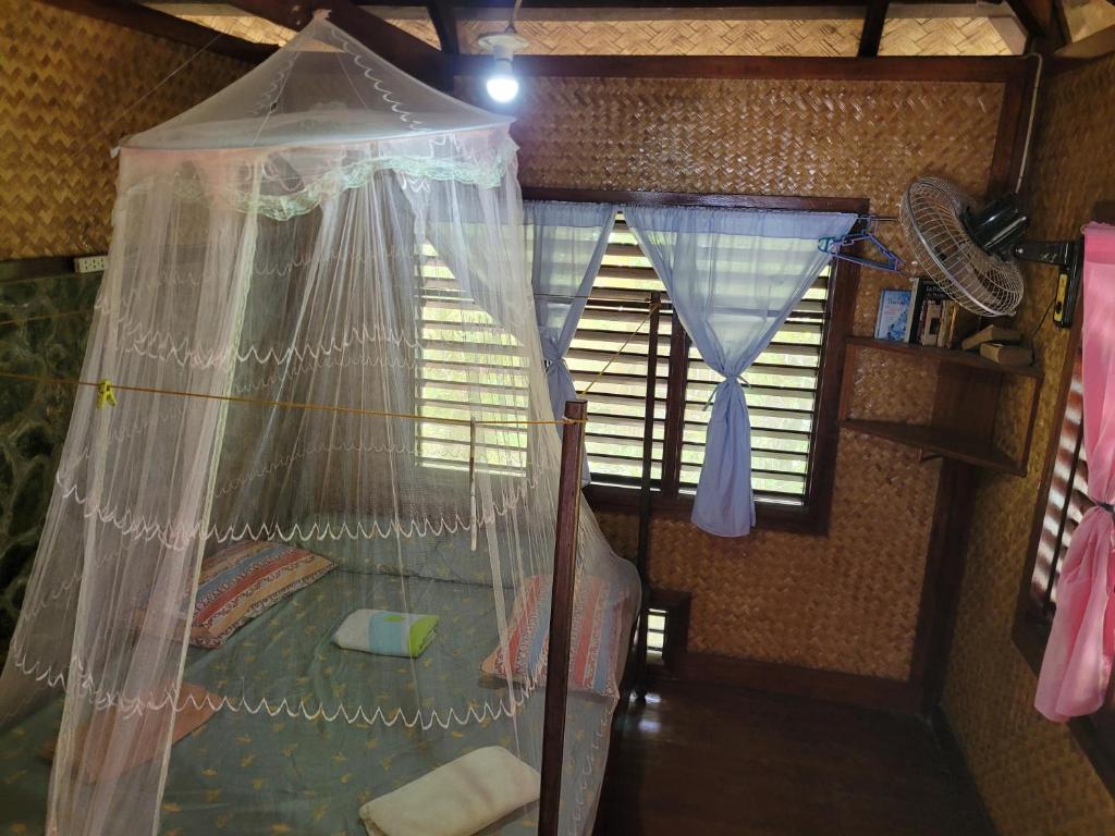 圣维森特MALAIKA RESORT的一间卧室配有一张带蚊帐的床