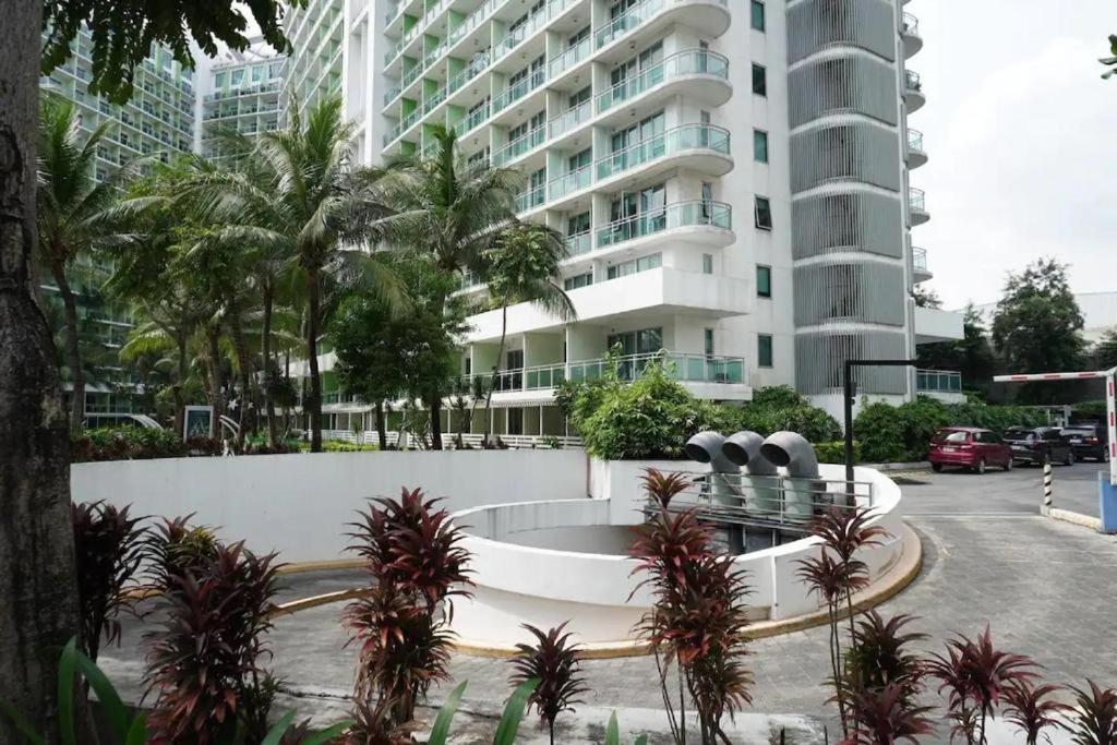 马尼拉Azure Urban Residences Beach and Resort by Vookley的一座白色的大建筑,前面有棕榈树