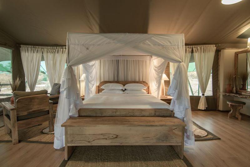Ol Pejeta ConservancyMAISHA SWEETWATERS CAMP的一间帐篷内带天蓬床的卧室