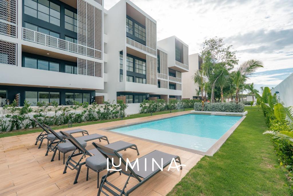 蓬塔卡纳Lumina at Flats Punta Cana Village的别墅 - 带游泳池和椅子