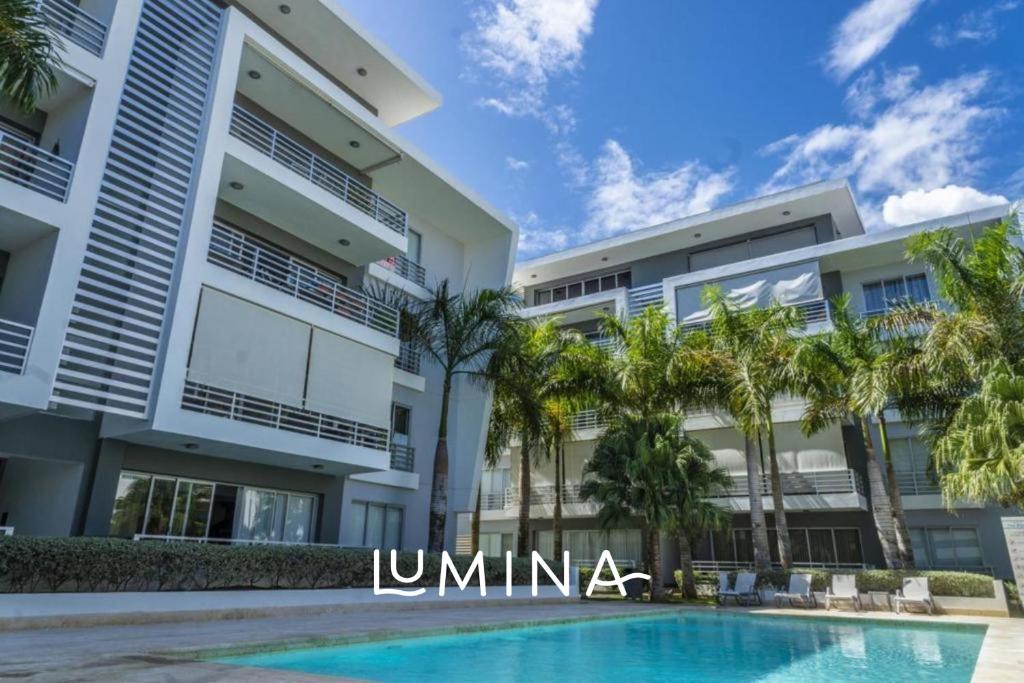 蓬塔卡纳Lumina at Palms Punta Cana Village的一座大型建筑,前面设有一个游泳池