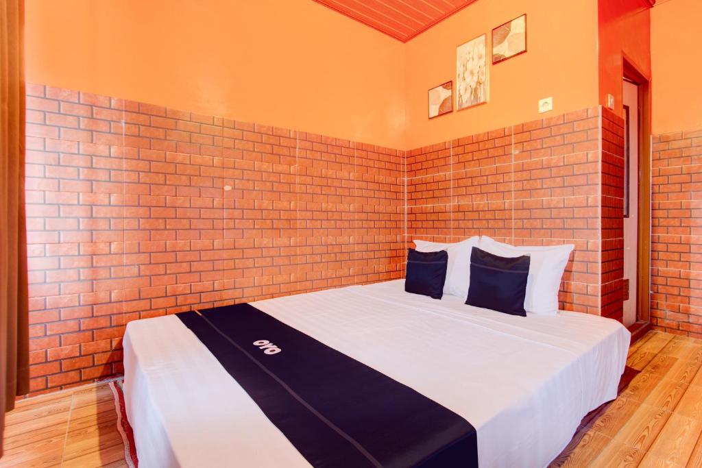 日惹Collection O 93742 Sidodadi Hotel Dan Resto的砖墙房间的一个床位