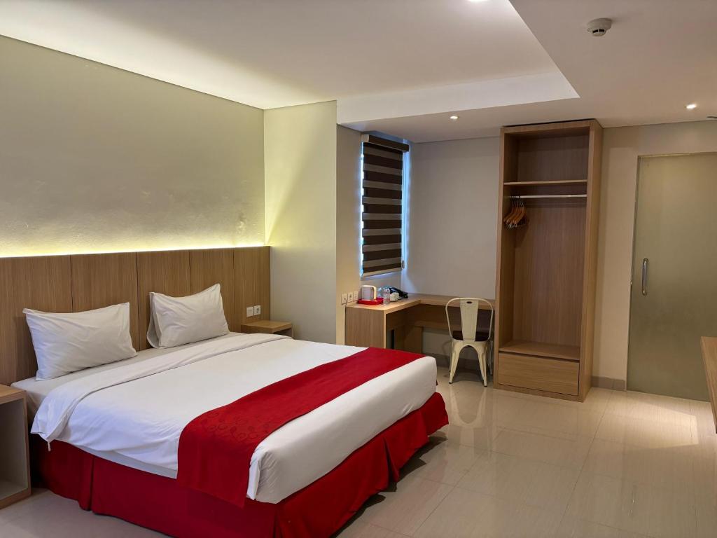 SeturanHotel Brothers Inn Babarsari的一间卧室配有一张带红色毯子的大床