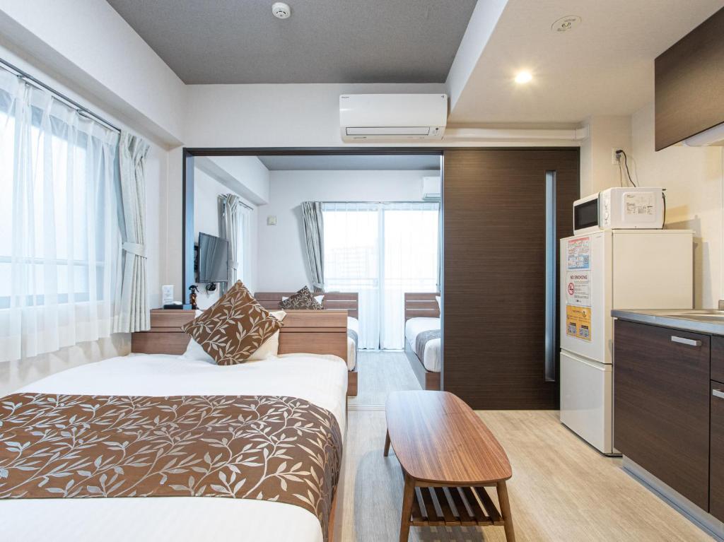 福冈Dream Inn Hakata的酒店客房带一张床和一个厨房