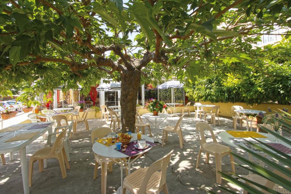 拉西约塔黎伯特克鲁马尔特酒店的树下带桌椅的庭院