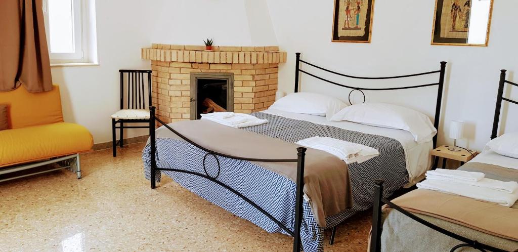 格拉维纳普利亚Masseria Santa Maria的一间卧室设有两张床和一个壁炉