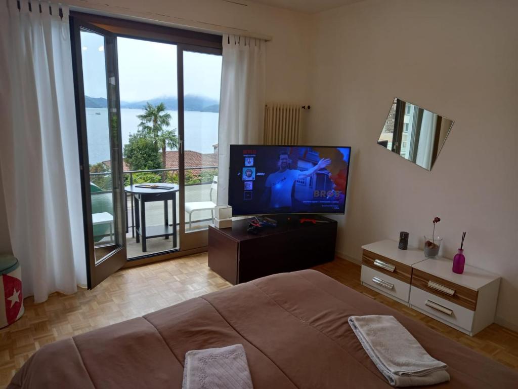 布里萨戈House1919 Via Valmara 14的一间卧室配有一张床和一台平面电视