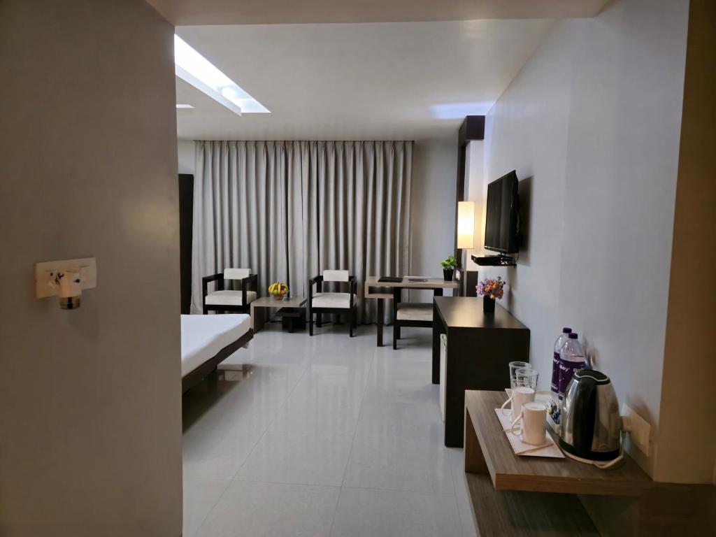 古瓦哈提Hotel Daaysco Oley Allo的酒店客房设有用餐区和客厅。