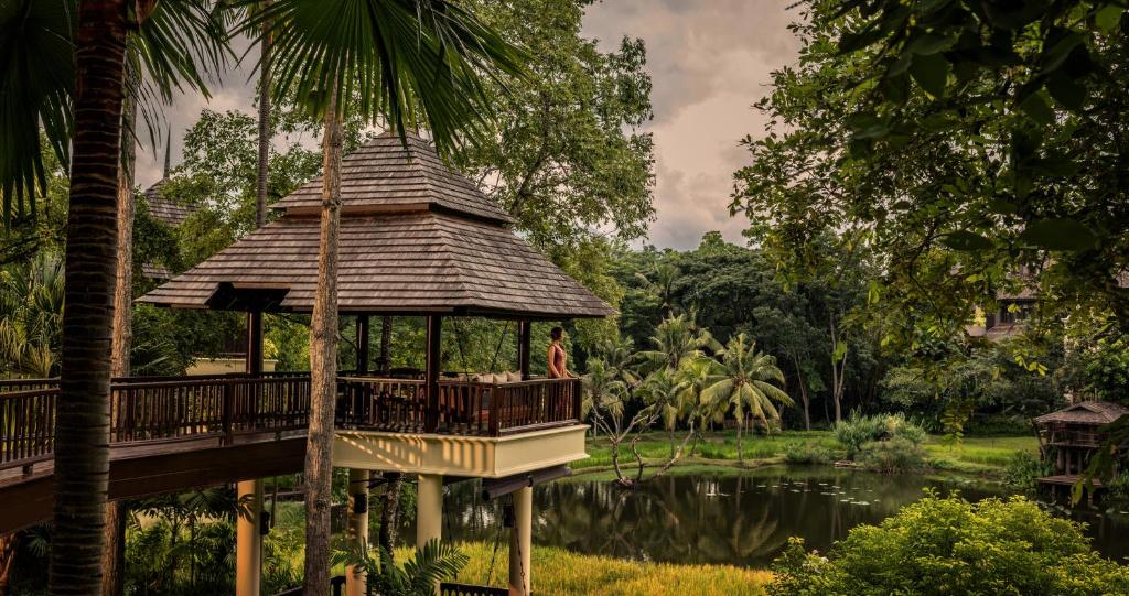 湄林Four Seasons Resort Chiang Mai的一个带池塘的公园内的凉亭