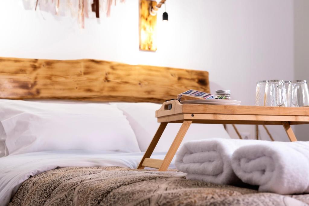 埃尔莫波利斯Onar Syros - Rustic Rooms的一张带木桌的床,旁边是一张带毛巾的桌子
