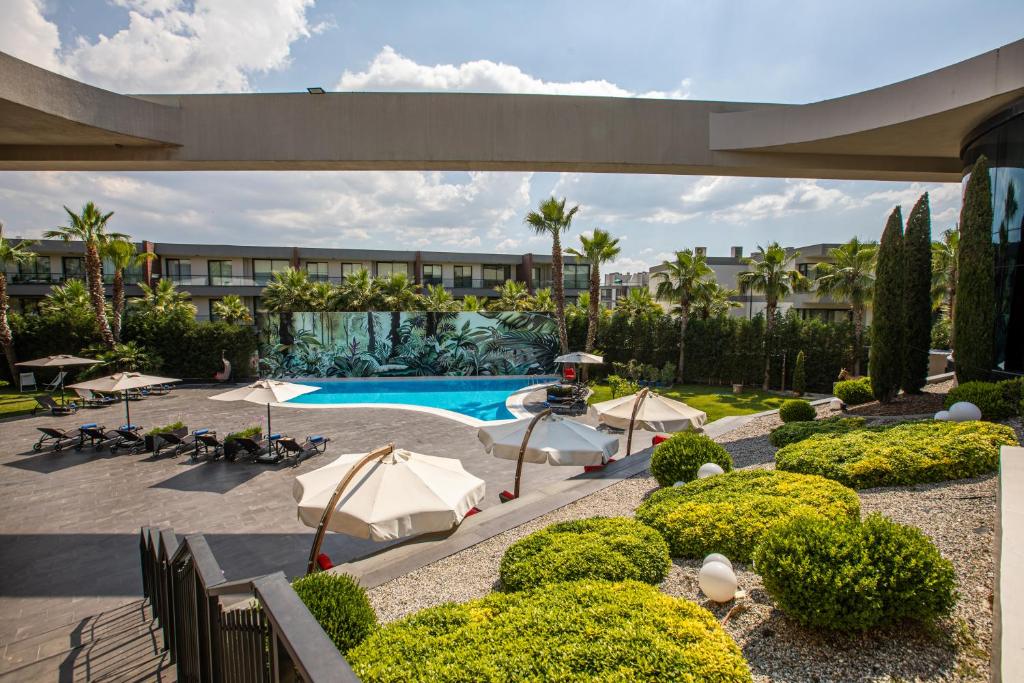 伊兹密尔伊兹密尔机场希尔顿逸林酒店的一个带游泳池的庭院和一个度假村