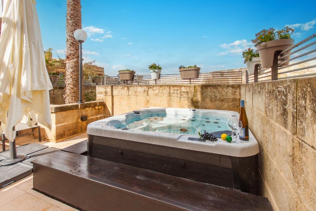MġarrHarbour Views Gozitan Villa Shared Pool - Happy Rentals的庭院顶部设有按摩浴缸。