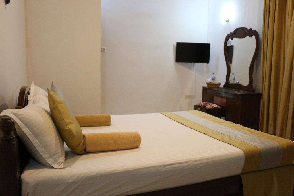 库鲁内格勒Xotic Resort Upper Floor的一间卧室配有一张带椅子的床和一台电视