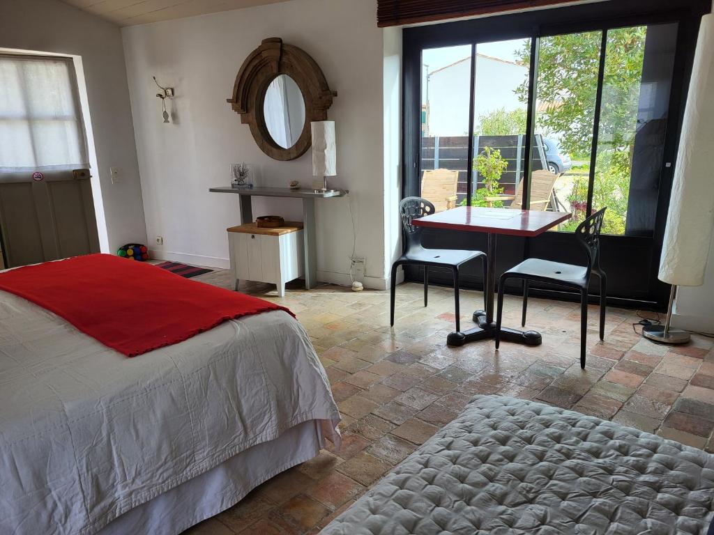 圣克莱门特德巴Ma Chambre d'Amis的一间卧室配有一张床、一张书桌和一面镜子