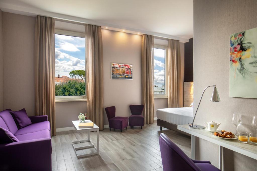 罗马The Guardian的酒店客房设有一张床和一张紫色沙发