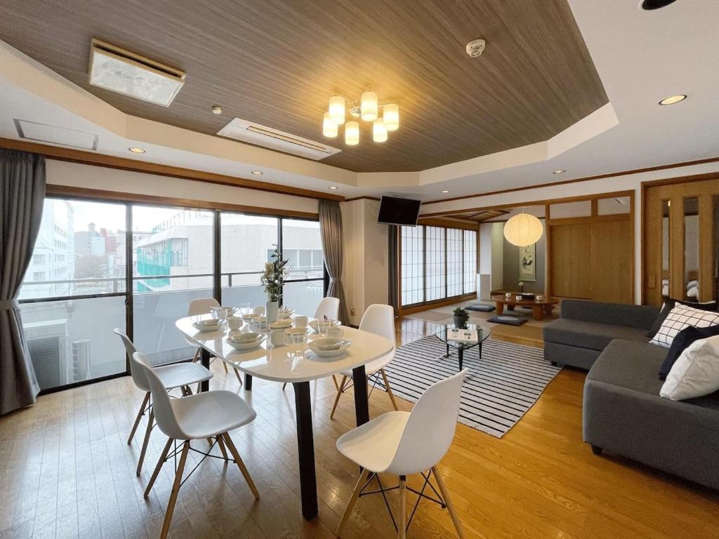 广岛bHOTEL M bld - Beautiful, spacious apartment next to Peace Park的客厅配有白色的桌子和椅子