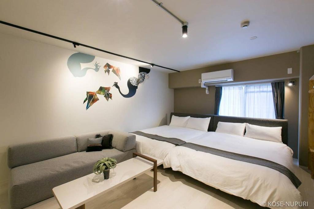 广岛bHOTEL Origaminn 402 - 5 mins PeacePark的一间卧室配有一张大床和一张沙发
