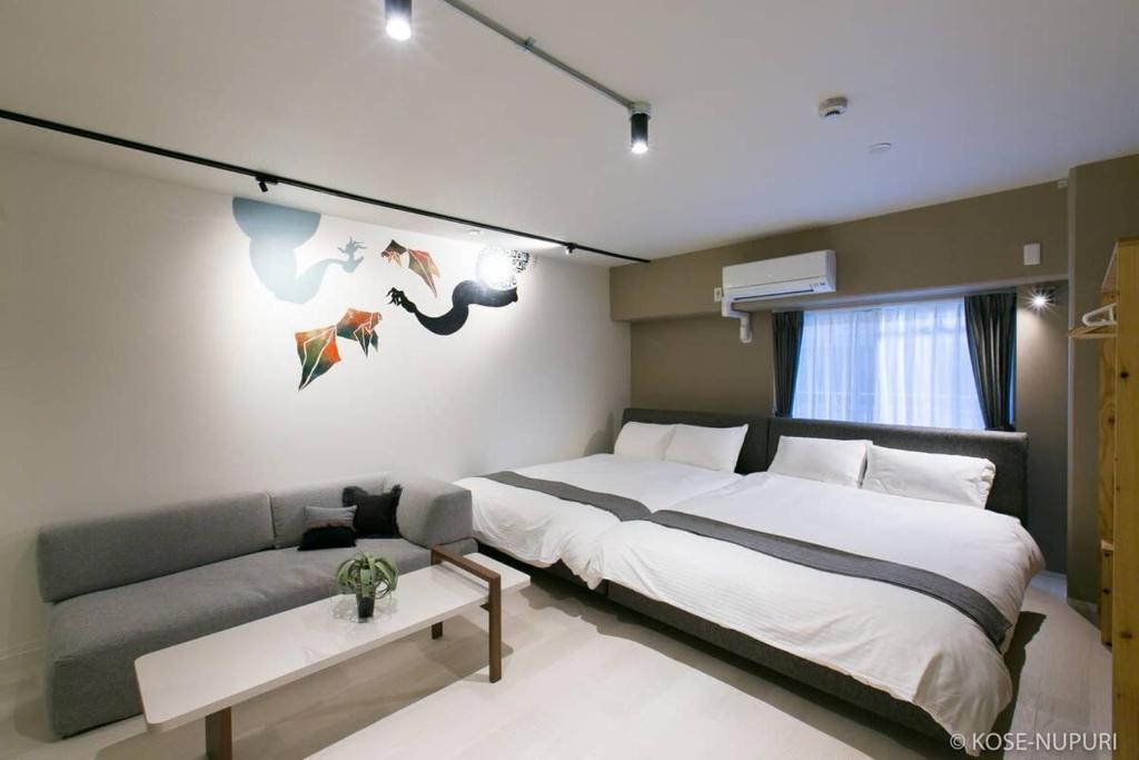广岛bHOTEL Origaminn 302 - 5 mins PeacePark的一间卧室配有一张大床和一张沙发
