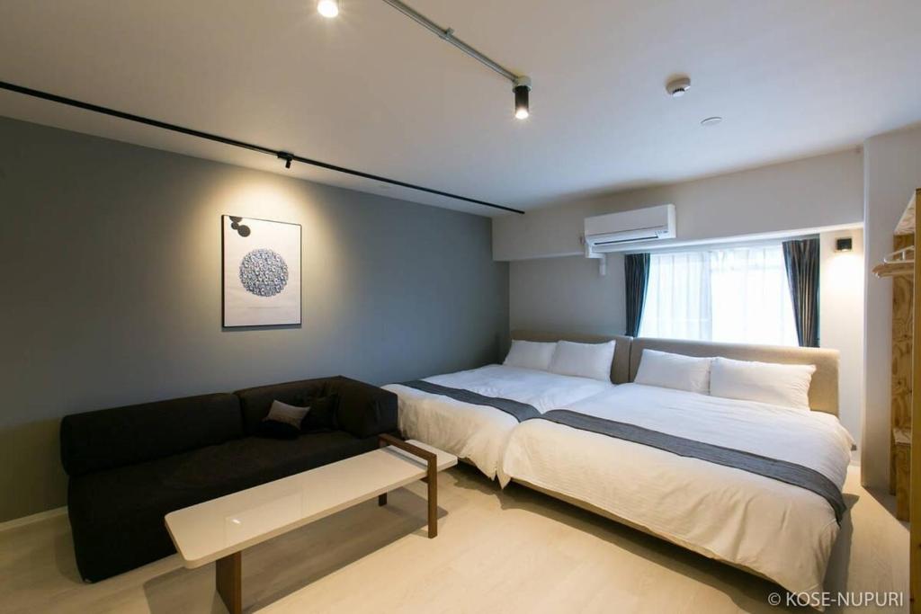 广岛bHOTEL Origaminn 502 - 5 mins PeacePark的一间卧室配有一张大床和一张沙发